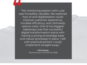 Quote card on a torn-paper background. A dark gray panel contains a testimonial by Phil Moody, Bunny Ennis Fund winner 2026, with red quotation marks at the top-left.